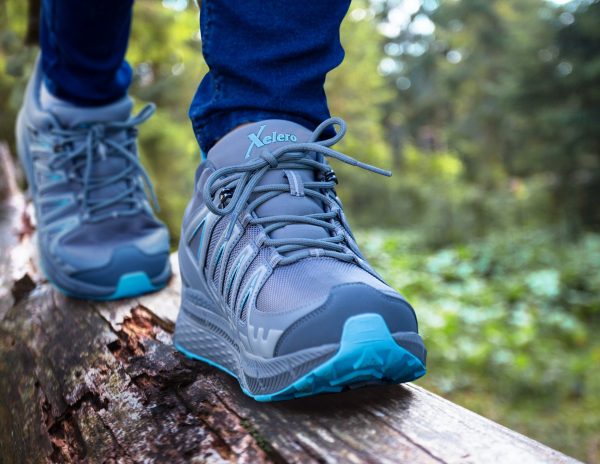 Picture of persons legs and feet while walking on a log while wearing Xelero shoes.